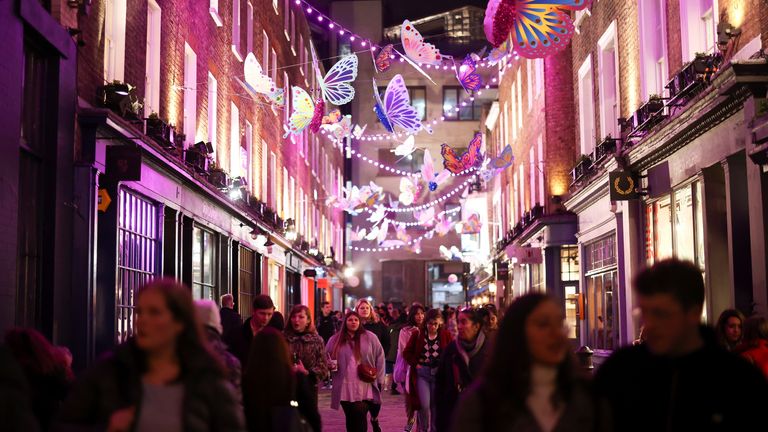 Les gens marchent sous les décorations lors de l'installation du kaléidoscope de Noël de Carnaby dans le centre de Londres