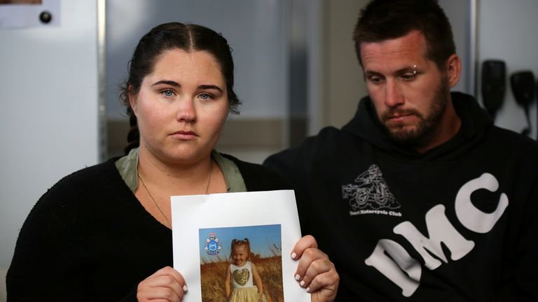 Cleo Smithâ€™s mother Ellie Smith, standing with her partner Jake Gliddon, holds up a photo of her missing daughter while addressing the case from a police truck at Blowholes campsite, outside Carnarvon, Australia, October 19, 2021. Picture taken October 19, 2021. AAP Image/POOL, James Carmody via REUTERS ATTENTION EDITORS - THIS IMAGE WAS PROVIDED BY A THIRD PARTY. NO RESALES. NO ARCHIVE. AUSTRALIA OUT. NEW ZEALAND OUT  