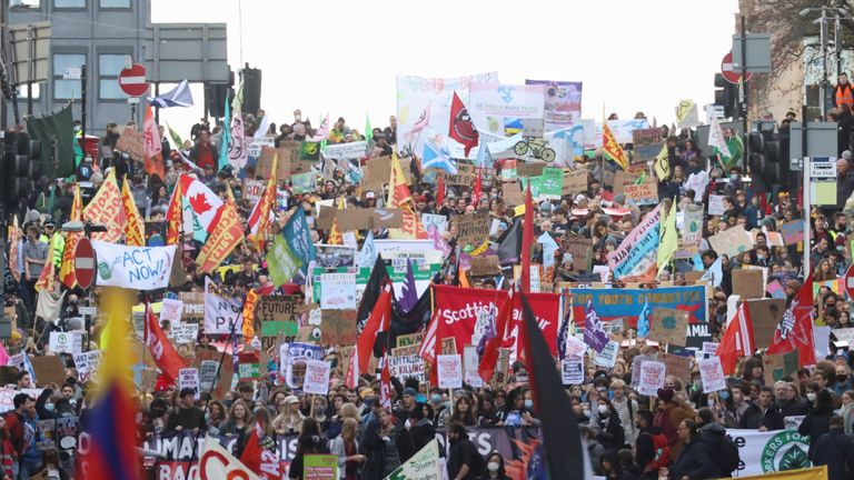 Des manifestants portent des pancartes et des drapeaux lors d'une marche Fridays for Future lors de la Conférence des Nations Unies sur les changements climatiques (COP26), à Glasgow, en Écosse, en Grande-Bretagne, le 5 novembre 2021. REUTERS/Yves Herman
