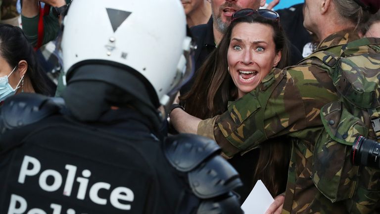 Brüksel'de bir gösterici çevik kuvvet polisiyle karşı karşıya