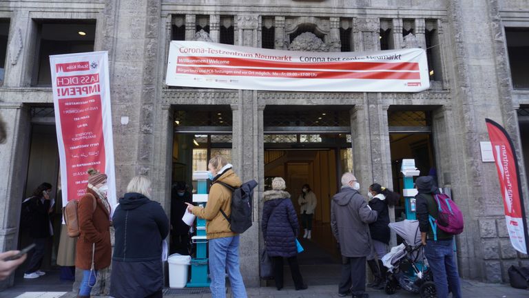 Des gens se tiennent devant un centre de test COVID à Cologne