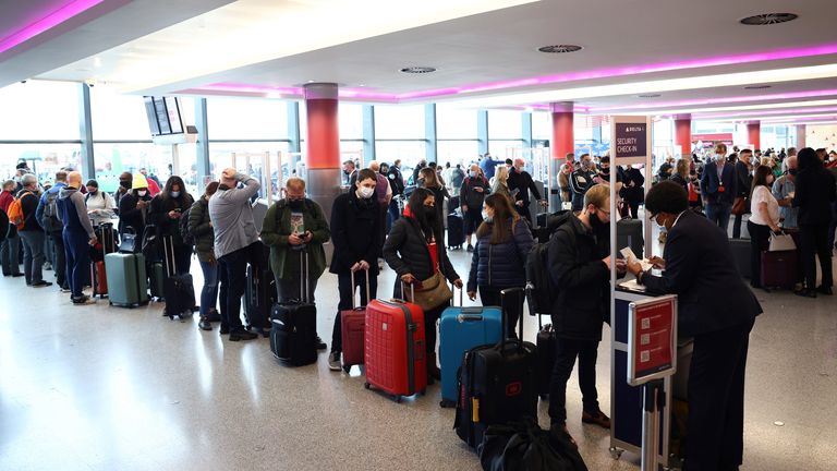 People queue to check into Virgin Atlantic and Delta Air Lines flights at Heathrow Airport Terminal 3, following the lifting of restrictions on the entry of non-U.S. citizens to the United States imposed to curb the spread of the coronavirus disease (COVID-19), in London, Britain, November 8, 2021. REUTERS/Henry Nicholls
