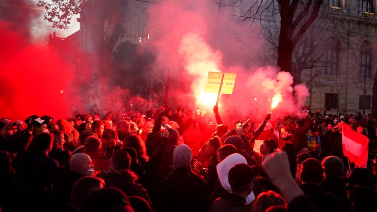 Demonstrators light flares during a demonstration against COVID lockdown measures in Vienna, Austria. Pic: AP