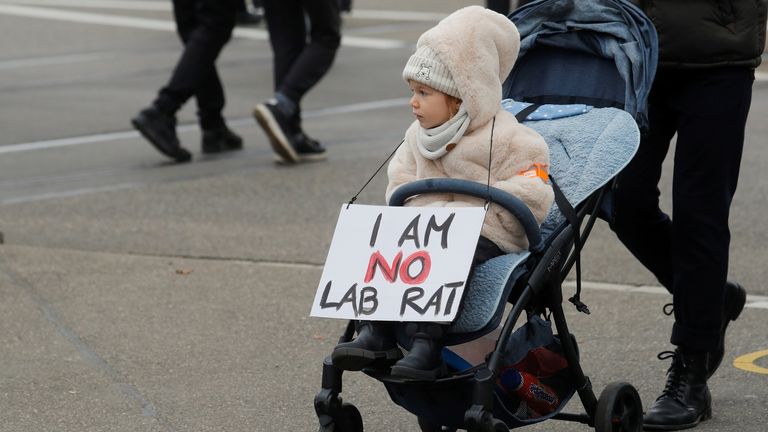 A sign hangs on a child as people protest against a planned coronavirus disease (COVID-19) law of the Swiss government, in Zurich, Switzerland November 20, 2021