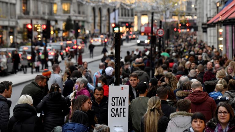 Shoppers walk past a message on a hand sanitiser station amid the coronavirus pandemic in Regent Street, London.