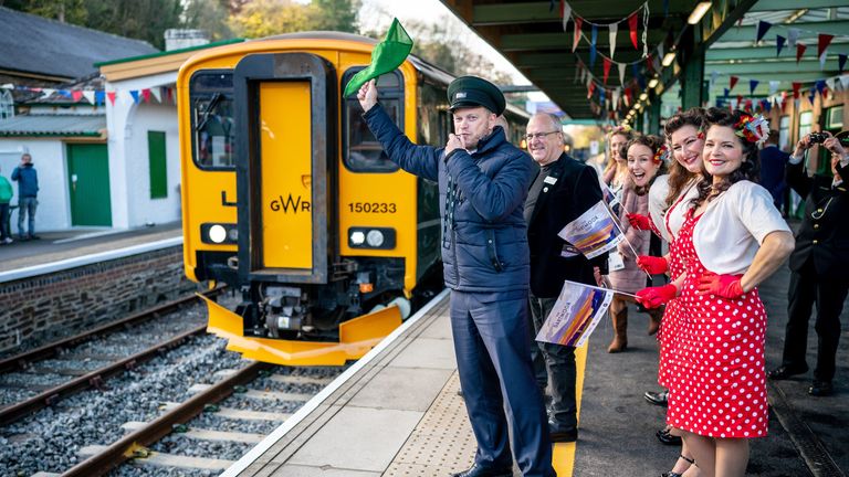 Transport Secretary Grant Shapps wears a hat, waves a flag and whistles off the GWR Dartmoor Line train from Oakhampton station after riding the first train on the newly reopened Dartmoor Line at Crediton Railway Station. Picture date: Wednesday November 17, 2021.