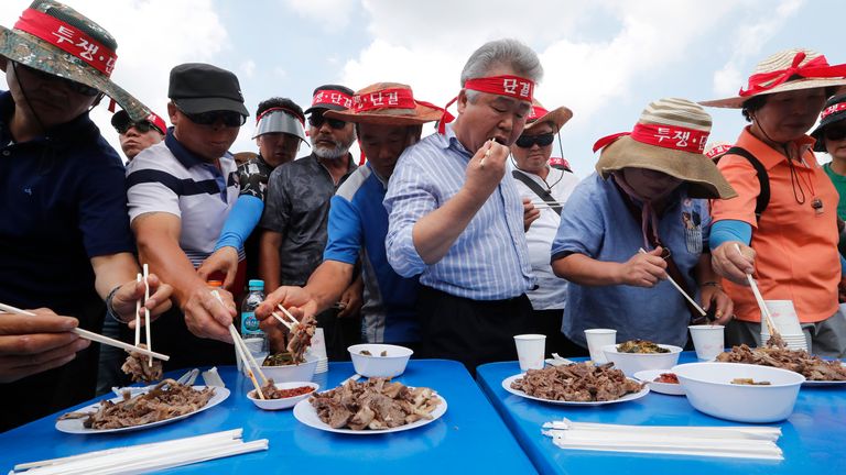 Members of Korean Dog Meat Association eat dog meat during a rally to support the practice, in Seoul, in 2019. Pic: AP