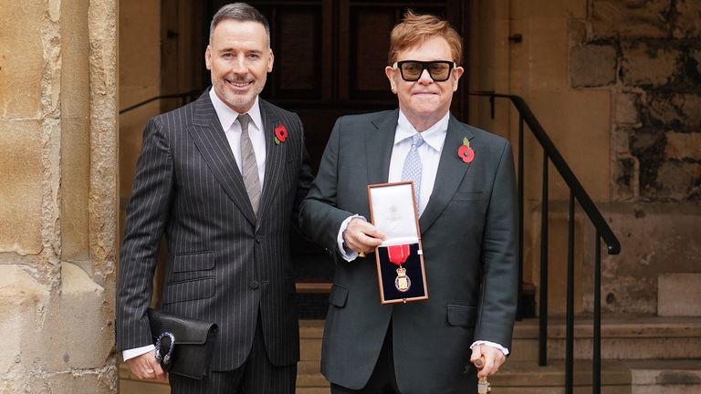 Sir Elton John, dengan rekannya David Furnish, setelah diangkat menjadi anggota Ordo Sahabat Kehormatan untuk layanan Musik dan Amal selama upacara penobatan di Kastil Windsor.  Gambar tanggal: Rabu 10 November 2021.