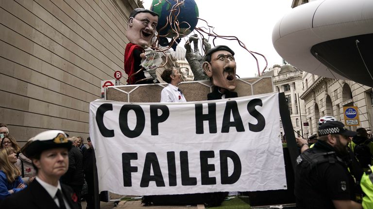 XR protesters carry a banner that says 'COP has failed'