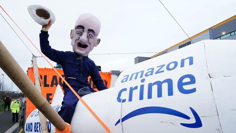An activist from Extinction Rebellion, wearing a giant Jeff Bezos head