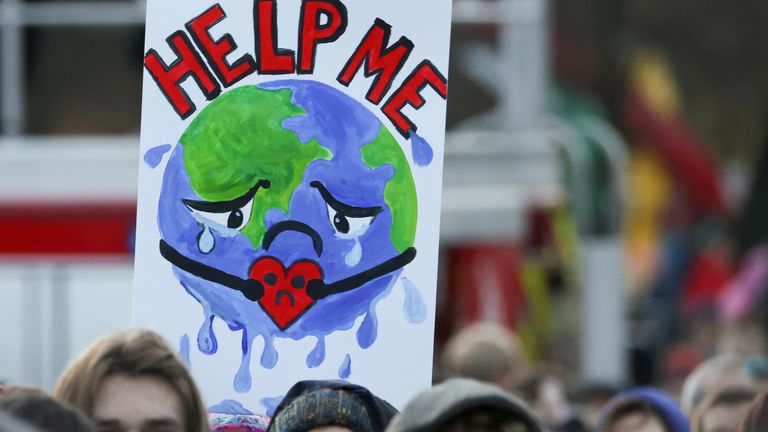 Les gens portent une pancarte alors qu'ils assistent à une manifestation lors de la Conférence des Nations Unies sur les changements climatiques (COP26), à Glasgow, en Écosse, en Grande-Bretagne, le 6 novembre 2021. REUTERS / Yves Herman