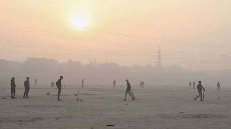 People play cricket on the floodplains of the Yamuna river on a smoggy morning in New Delhi, India, November 17, 2021. REUTERS/Anushree Fadnavis
