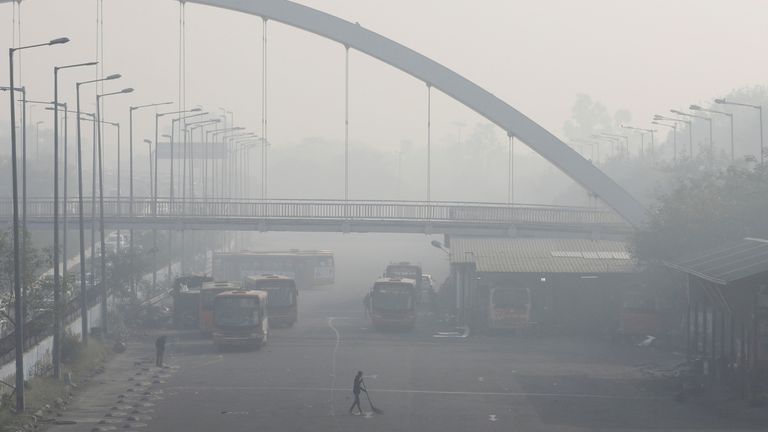 A man sweeps inside a bus depot on a smoggy morning in New Delhi, India, November 16, 2021. REUTERS/Anushree Fadnavis
