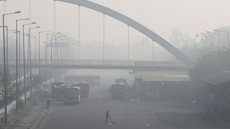 A man sweeps inside a bus depot on a smoggy morning in New Delhi, India, November 16, 2021. REUTERS/Anushree Fadnavis
