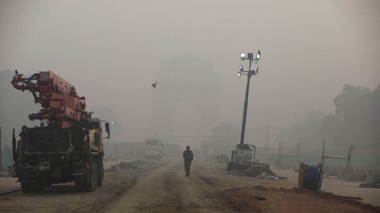An Indian paramilitary soldier walks near India Gate which is shrouded in smog, in New Delhi, India, November 5, 2021. REUTERS/Anushree Fadnavis

