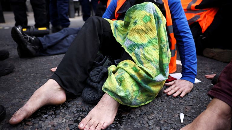 Insulate Britain activists have their hands and feet glued to the pavement as they block a road outside the Houses of Parliament during a protest in London, Britain November 4, 2021. REUTERS/Henry Nicholls
