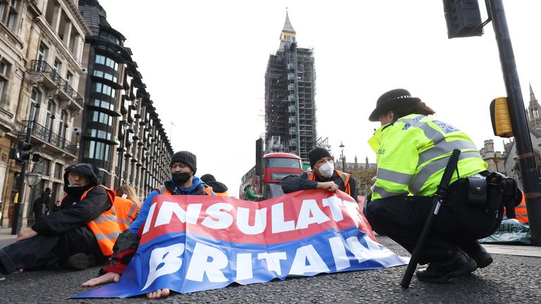 A police officer speaks to protesters from Insulate Britain as they block Great George Street in Parliament Square, central London. Picture date: Thursday November 4, 2021.
