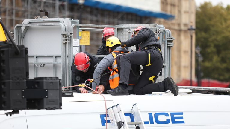 A protester from Insulate Britain is removed from the roof of police van during a protest in Parliament Square, central London. Picture date: Thursday November 4, 2021.
