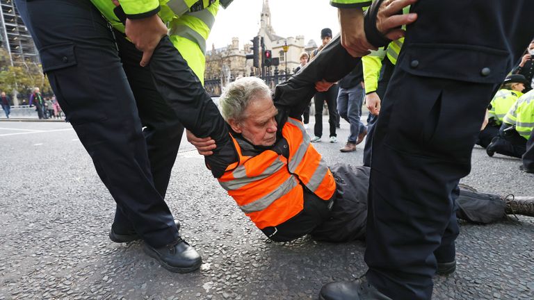 Des policiers retirent un manifestant d'Isulate Britain alors qu'ils bloquent la route sur la place du Parlement, dans le centre de Londres.  Date de la photo : jeudi 4 novembre 2021.