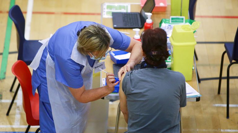 A woman receives an Oxford-AstraZeneca coronavirus disease (COVID-19) vaccine 