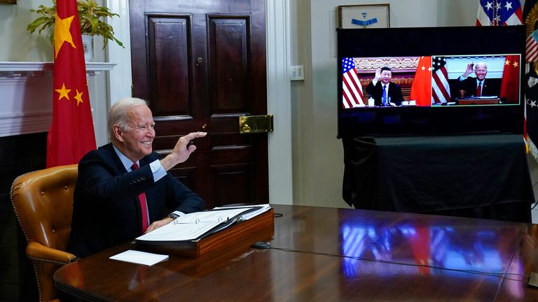 President Joe Biden waves as he meets virtually with Chinese President Xi Jinping from the Roosevelt Room of the White House in Washington