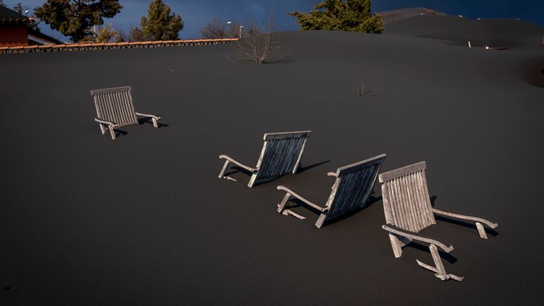 Liegen bedeckte Stühle auf der Terrasse eines Hauses, während der Vulkan weiter ausbricht.  Foto: AP