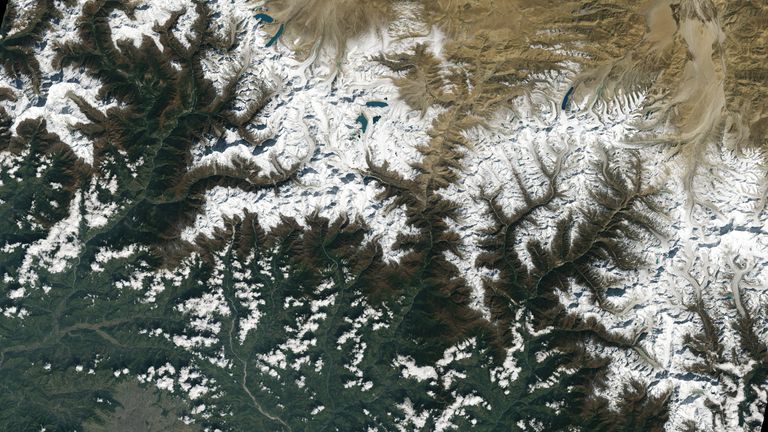 Kota Kathmandu, Nepal, terlihat di kiri bawah gambar Landsat 9 ini, terletak di lembah selatan Pegunungan Himalaya antara Nepal dan Cina.  Di tengah atas gambar ini Anda dapat melihat gletser dan danau yang dibentuk oleh air lelehan glasial.