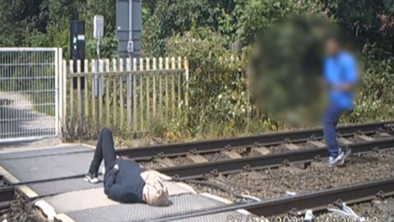A teenage boy lying down at a level crossing in Broxtowe, Nottinghamshire
