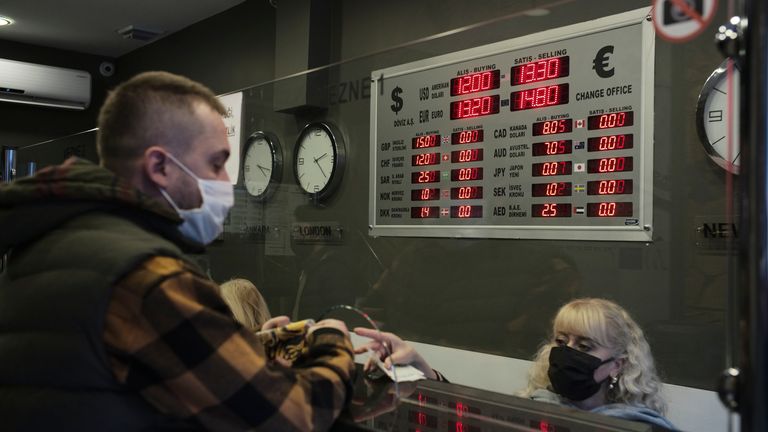 A man changes Turkish lira for US dollars and euros at a currency exchange shop, in Ankara. Pic: AP