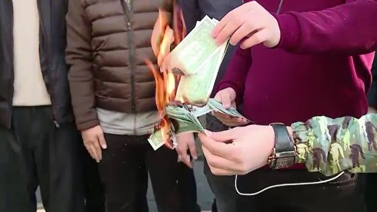 Lira notes are burned by young men angry at the currency crisis