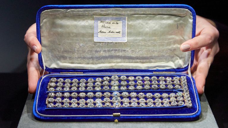 A staff holds a blue velvet case containing a pair of diamond bracelets, with approximately 140 to 150 carats and owned by Queen Marie-Antoinette of France, in silver and yellow gold, circa 1776, during a preview at Christie&#39;s before their auction sale in Geneva, Switzerland, November 3, 2021. REUTERS/Denis Balibouse