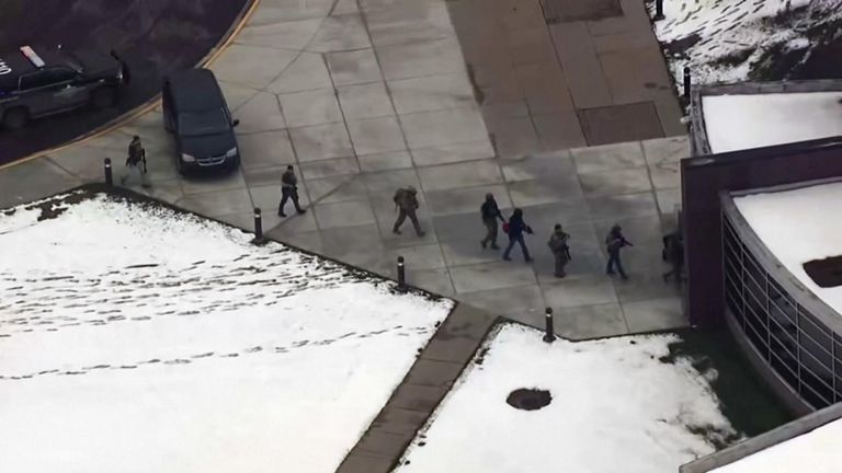 AERIAL OF ARMED LAW ENFORCEMENT OFFICERS HEADING INTO SCHOOL