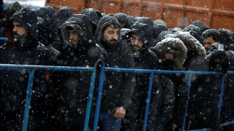 Migrants gather during snowfall at a transport and logistics centre near the Belarusian-Polish border in the Grodno region, Belarus November 23, 2021. REUTERS/Kacper Pempel
