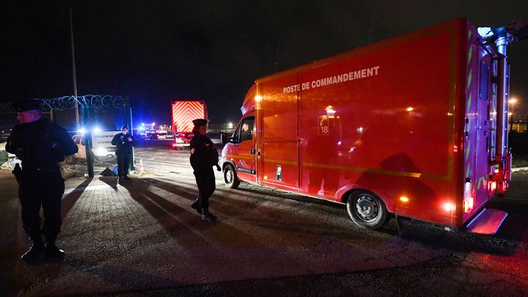 Des policiers se tiennent à côté d'un poste de commandement des pompiers arrivant dans le port de Calais après la mort de 27 migrants dans le naufrage de leur bateau au large de Calais, le 24 novembre 2021. (Photo de FRANCOIS LO PRESTI / AFP) (Photo de FRANCOIS LO PRESTI /AFP via Getty Images)