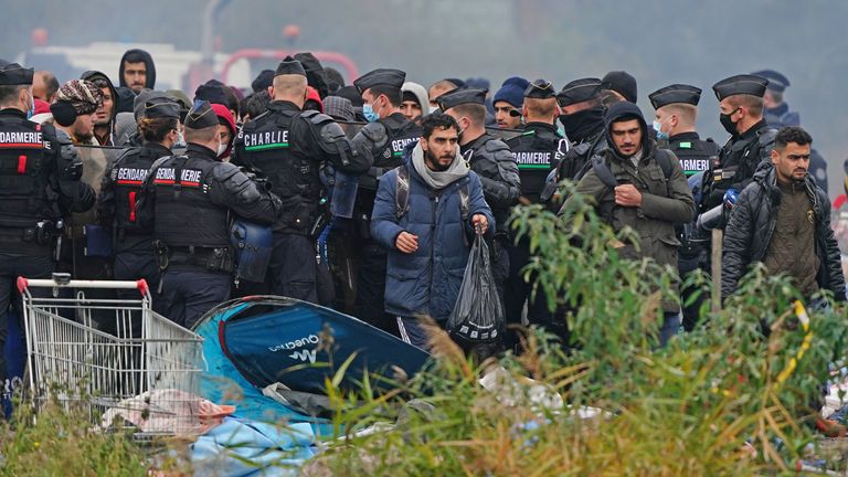Migrants at a makeshift camp on the site of a former industrial complex in Grande-Synthe, east of Dunkirk, as French police are evacuating migrants from the site, where at least 1,500 people had gathered in hopes of making it across the English Channel to Britain. Picture date: Tuesday November 16, 2021.
