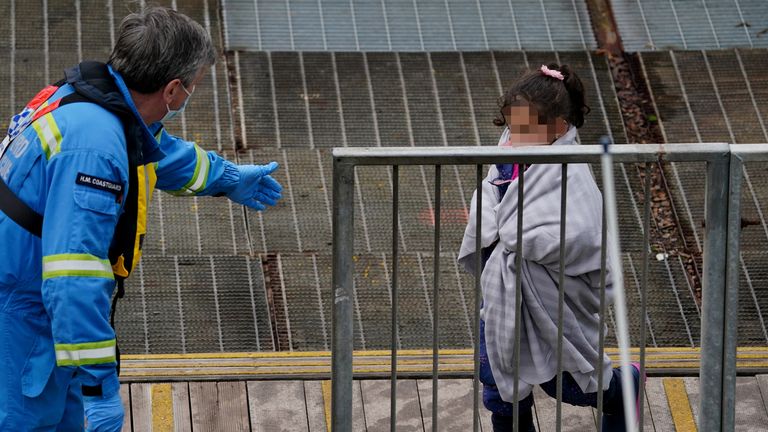 EDITORS NOTE Children&#39;s faces have been pixelated as the PA Picture Desk has been unable to gain the necessary permission to photograph a child under 16 on issues involving their welfare. A young girl amongst a group of people thought to be migrants is helped by a Coastguard officer as she arrives in Dover, Kent, after being rescued by the Dover lifeboat, following a small boat incident in the Channel. Picture date: Thursday November 11, 2021.