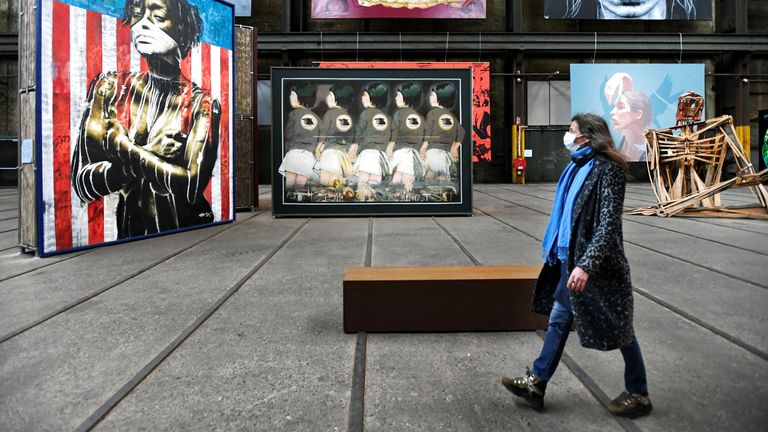 Une femme portant un masque regarde le street art alors qu'elle se promène au International Street Art Museum à la suite des nouvelles restrictions sociales annoncées par le gouvernement néerlandais, alors que les Pays-Bas se battent pour contrôler la propagation de la maladie à coronavirus (COVID-19), à Amsterdam, Pays-Bas 14 octobre 2020
