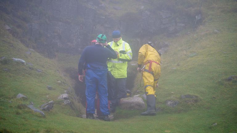 Rescuers at the entrance of the Ogof Ffynnon Ddu cave system near Penwyllt, Powys in the Brecon Beacons, Wales, as rescue mission is underway to save a man who has been trapped inside a cave, after falling on Saturday. Because of the injuries suffered in the fall the trapped man is said to be unable to climb out of the cave. Picture date: Monday November 8, 2021.
