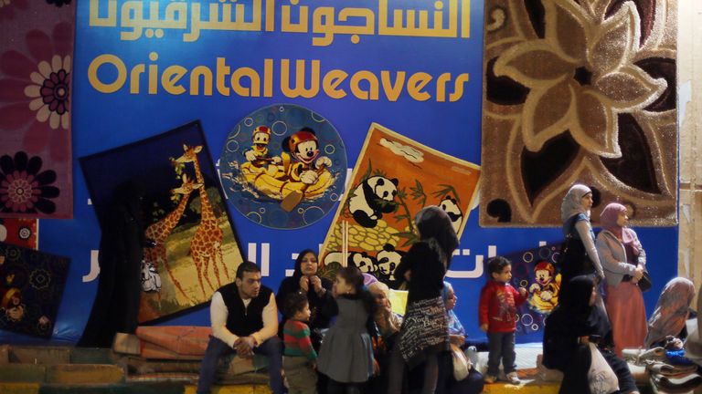 Des gens s'assoient devant le marché d'Egypt's Oriental Weavers, le plus grand fabricant de tapis tissés à la machine, lors de son exposition annuelle au Caire le 22 mars 2014.