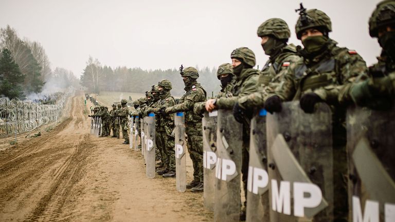 Polish military police stay on guard at the Poland/Belarus border near Kuznica, Poland, in this photograph released by the Territorial Defence Forces, November 12, 2021. 
