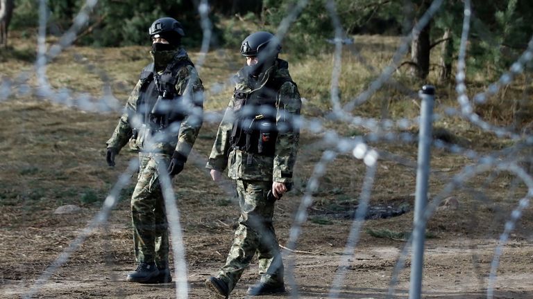 Polish police officers walk at the Belarusian-Polish border amid the migrant crisis, as seen from the Grodno region, Belarus, November 22, 2021. REUTERS/Kacper Pempel
