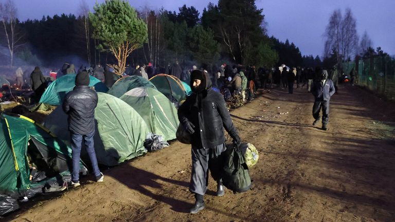 Migrants walk in a camp near the Bruzgi - Kuznica checkpoint on the Belarusian-Polish border in the Grodno region, Belarus November 18, 2021. Maxim Guchek/BelTA/Handout via REUTERS ATTENTION EDITORS - THIS IMAGE HAS BEEN SUPPLIED BY A THIRD PARTY. NO RESALES. NO ARCHIVES. MANDATORY CREDIT.
