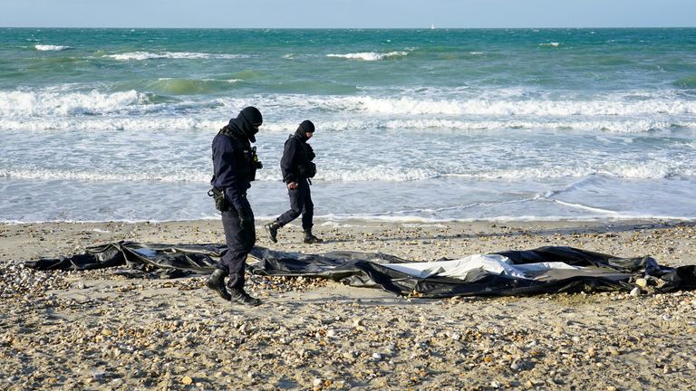 French police officers pass a deflated dinghy on the beach in Wimereux near Calais as migrants continue to launch small boats along the coastline in a bid to cross the Channel towards the UK. Picture date: Thursday November 18, 2021.
