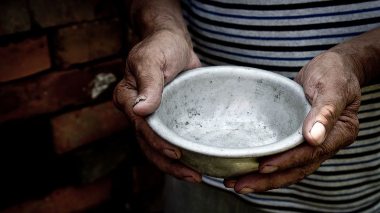 The poor old man&#39;s hands hold an empty bowl. The concept of hunger or poverty. Selective focus. Poverty in retirement.Homeless. Alms. Istock