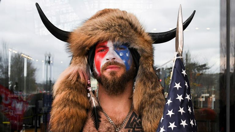 FOTO FILE: Jacob Anthony Chansley, juga dikenal sebagai Jake Angeli, dari Arizona, berpose dengan wajahnya dicat dengan warna bendera AS saat para pendukung Presiden AS Donald Trump berkumpul di Washington, AS, 6 Januari 2021. REUTERS/Stephanie Keith /File Foto