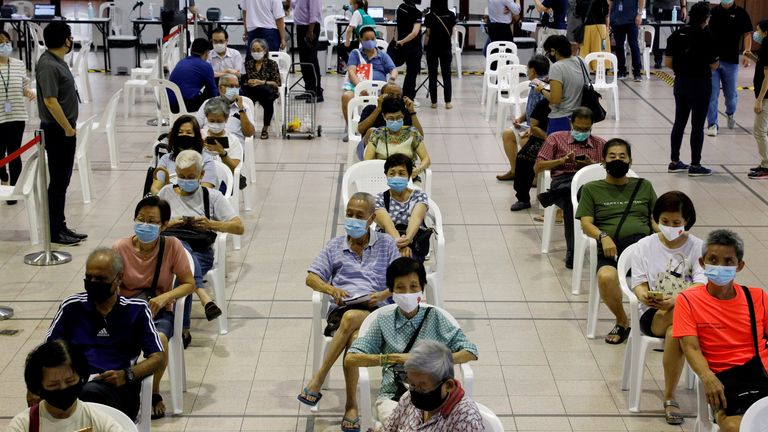 People wait in an observation area after getting a dose of the COVID-19 vaccine