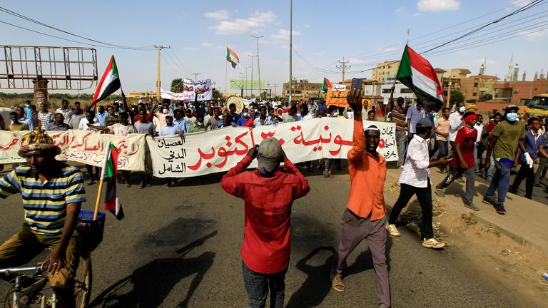 FILE PHOTO: Protesters carry a banner and national flags as they march against the Sudanese military&#39;s recent seizure of power and ousting of the civilian government, in the streets of the capital Khartoum, Sudan October 30, 2021. REUTERS/Mohamed Nureldin/File Photo