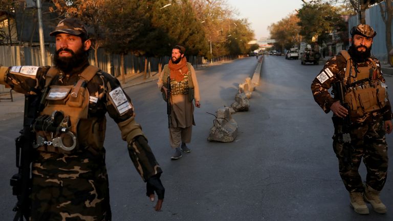 Taliban fighters arrive at the site of explosions at a military hospital in Kabul