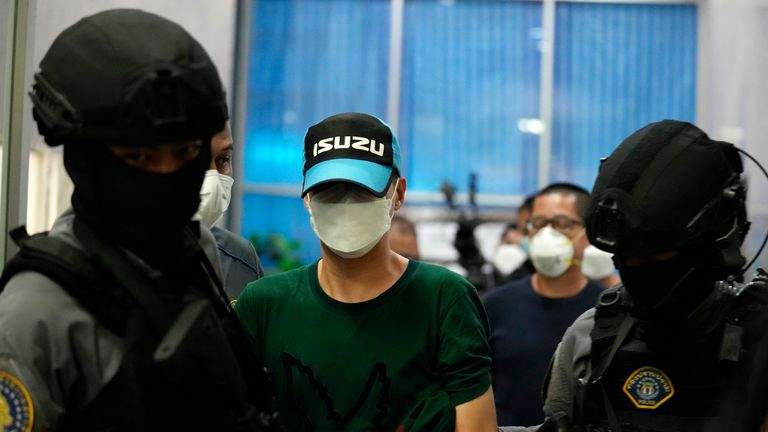 Thai police escort the former police Thitisan Utthanaphon known as "Jo Ferrari" while leaving the Crime Suppression Division in Bangkok, Thailand, Thursday, Aug. 26, 2021. A Thai police colonel known as "Jo Ferrari" due to his collection of fine cars, who was wanted on suspicion of involvement in the death of a detained drug dealer who was allegedly being shaken down for cash, turned himself in on Thursday amid a nationwide manhunt. (AP Photo/Sakchai Lalit).