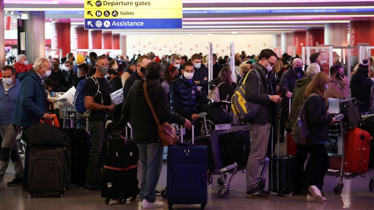 People queue to check into Virgin Atlantic and Delta Air Lines flights at Heathrow Airport Terminal 3, following the lifting of restrictions on the entry of non-U.S. citizens to the United States imposed to curb the spread of the coronavirus disease (COVID-19), in London, Britain, November 8, 2021. REUTERS/Henry Nicholls
